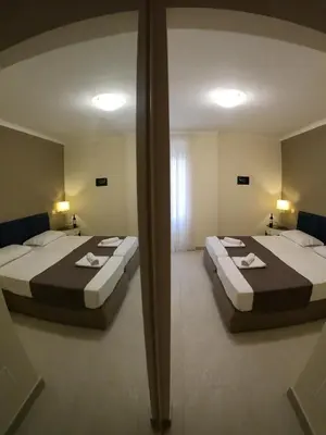 two beds in a room with a mirror at Relais central Turati in Rome