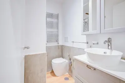 a white bathroom with a sink and a toilet at GuestHost - Spanish Steps Luxury Apartment in Rome