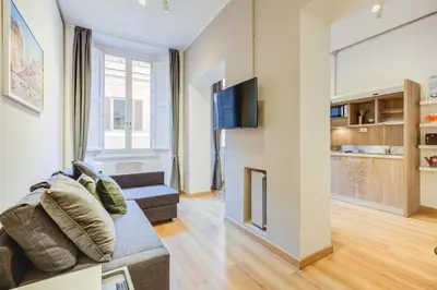 a living room with a couch and a tv at GuestHost - Spanish Steps Luxury Apartment in Rome