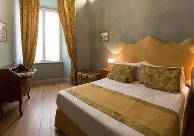 a bedroom with a bed and a desk and a window at Navona Grand Suite in Rome