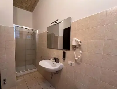a bathroom with a sink and a phone on the wall at Saint Peter Loft in Rome