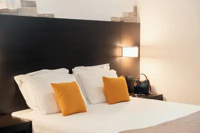 a bed with two orange pillows and a black headboard at Saint Peter Loft in Rome