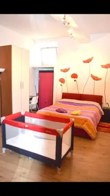 a bedroom with a bed with fake flowers on the wall at New studio a Trastevere in Rome