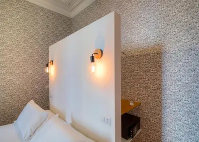 a bedroom with a white wall with lights on it at App Beccaria Apartments in Rome in Rome