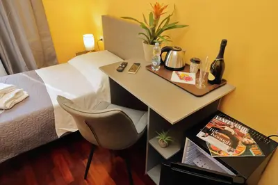 a hotel room with a bed and a table with a chair at Porta Pia Comfy Rooms in Rome