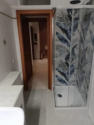 a glass shower in a bathroom with a hallway at City Break Nomentana in Rome