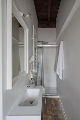 a white bathroom with a sink and a mirror at Palazzo Lupardi Relais in Rome