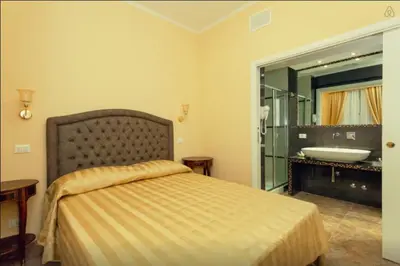 a bedroom with a bed and a bathroom with a sink at VIA VENETO SUITE 107 in Rome