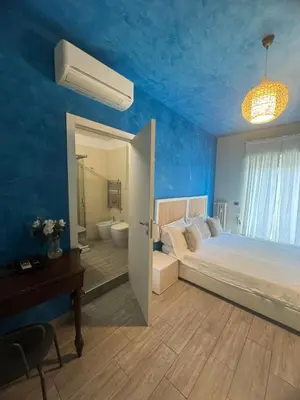 a blue bedroom with a bed and a bathroom at Stileroma in Rome