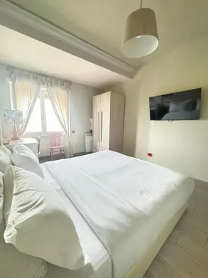 a bedroom with a white bed and a desk and a window at Stileroma in Rome