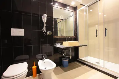 a bathroom with a shower and a toilet and a sink at VIA VENETO SUITE 104 in Rome