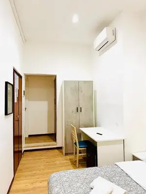 a white room with a desk and a bed at Tawhid Accomodation in Rome