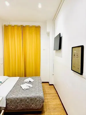 a bedroom with a bed with an orange curtain at Tawhid Accomodation in Rome
