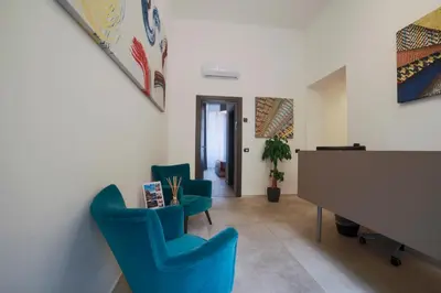a living room with blue chairs and a piano at Bespoke Roma Suites in Rome