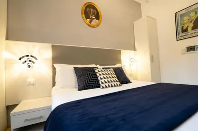 a bedroom with a blue and white bed and a clock at Archi di Roma Guest House in Rome