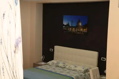a bedroom with a bed and a picture of a building at Villa Matissa Apartments in Rome