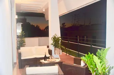 a balcony with a white couch and a table and chairs at Terrazza San Giovanni apartment in Rome