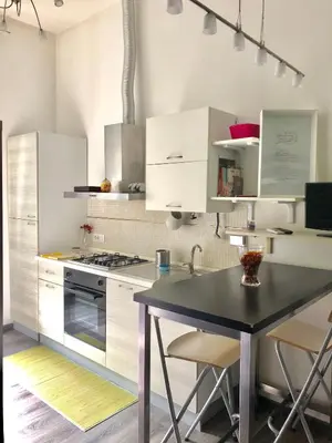 a kitchen with white cabinets and a black table at Luxy Vatican Apartment in Rome