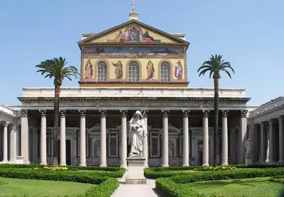 a large building with a statue and palm trees at A casa di Armando in Rome