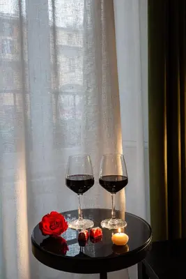two glasses of wine on a table next to a window at Tula Inn in Rome