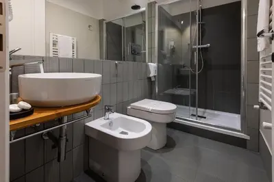 a bathroom with a sink and a toilet and a shower at Tula Inn in Rome