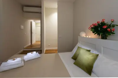 a bedroom with a white bed with a vase of flowers at Tula Inn in Rome