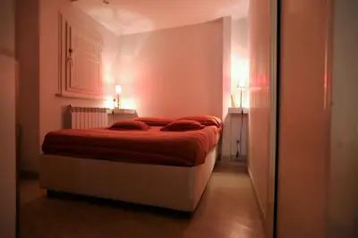 a bedroom with a bed with red sheets and two lamps at Grotte Flat in Rome