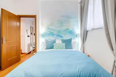 a bedroom with a large bed with blue pillows at BDC - Opera Studio in Rome