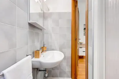 a white bathroom with a sink and a mirror at BDC - Opera Studio in Rome