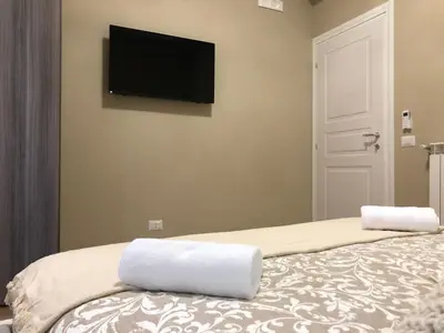 a bedroom with a bed with a flat screen tv on the wall at Pantheon Luxury Suite in Rome