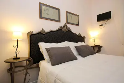 a bedroom with a large white bed with two pillows at Amica Roma Guest House in Rome