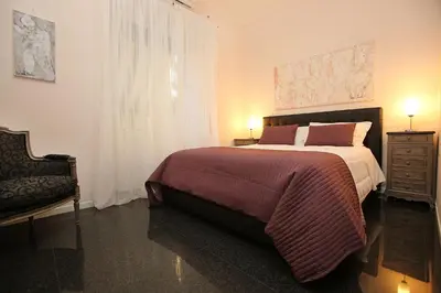 a bedroom with a large bed and a chair at Amica Roma Guest House in Rome