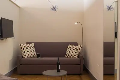 a living room with a couch and a table at Tritone 125 Suite in Rome