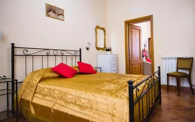 a bedroom with a bed with two red pillows on it at TrevInn Suites in Rome