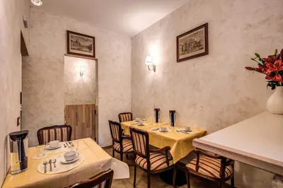 a restaurant with two tables and chairs in a room at AMICI GUESTHOUSE in Rome