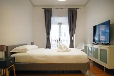 a bedroom with a large bed and a television at Elegant Apartment Via Veneto by Varental in Rome