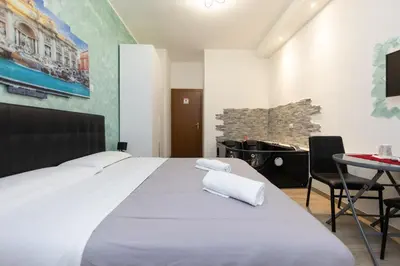 a bedroom with a white bed with a desk and a computer at Imperiale Top in Rome