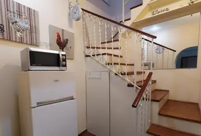a staircase in a house with a tv on a refrigerator at Colosseum private terrace in Rome