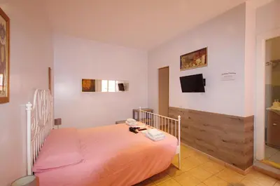 a bedroom with a bed and a tv on the wall at Old Bakery Rome GuestHouse in Rome