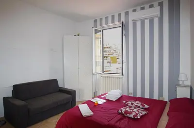 a living room with a bed and a chair at Old Bakery Rome GuestHouse in Rome