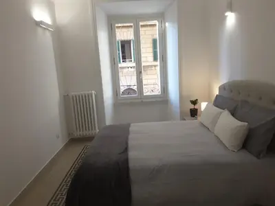a bedroom with a large bed and a window at Dino Apartment in Rome