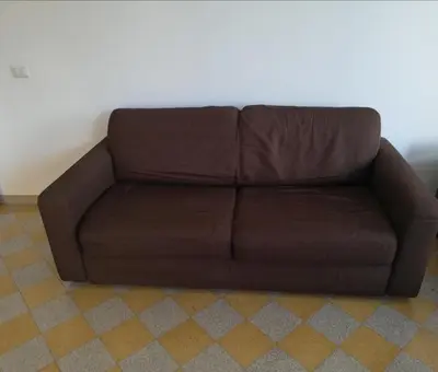 a brown couch sitting in a living room at Dino Apartment in Rome