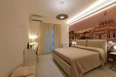 a bedroom with a large bed and a building on the wall at San Pietro Moonlight Luxury Apartment in Rome