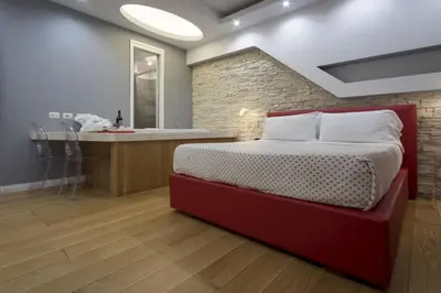 a bedroom with a red bed and a kitchen at Luxury on the River in Rome
