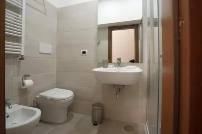 a bathroom with a sink and a toilet and a mirror at Borgo Pio 91 in Rome