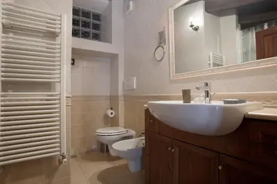 a bathroom with a sink and a toilet and a mirror at Borgo Pio 91 in Rome
