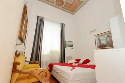 a white bedroom with a bed and a chair at Sanctuary Home in Rome