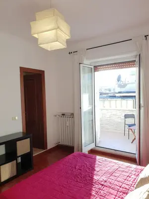 a bedroom with a bed and a large sliding glass door at Pigneto Suite appartamento 50 m da metro C in Rome