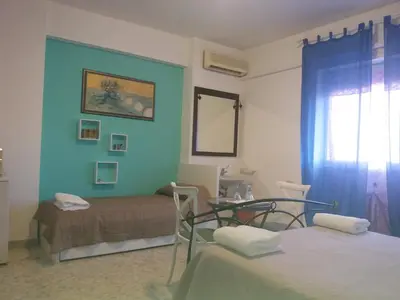 a room with two beds and a table and a window at Apartament Silvy Trastevere in Rome