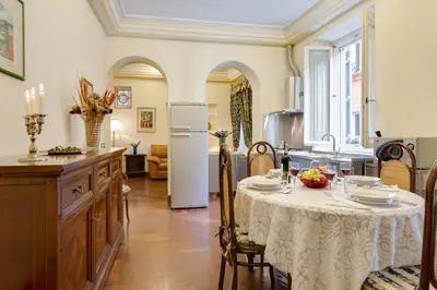 a kitchen with a table with a white table cloth at Vittoria Street Charming in Rome
